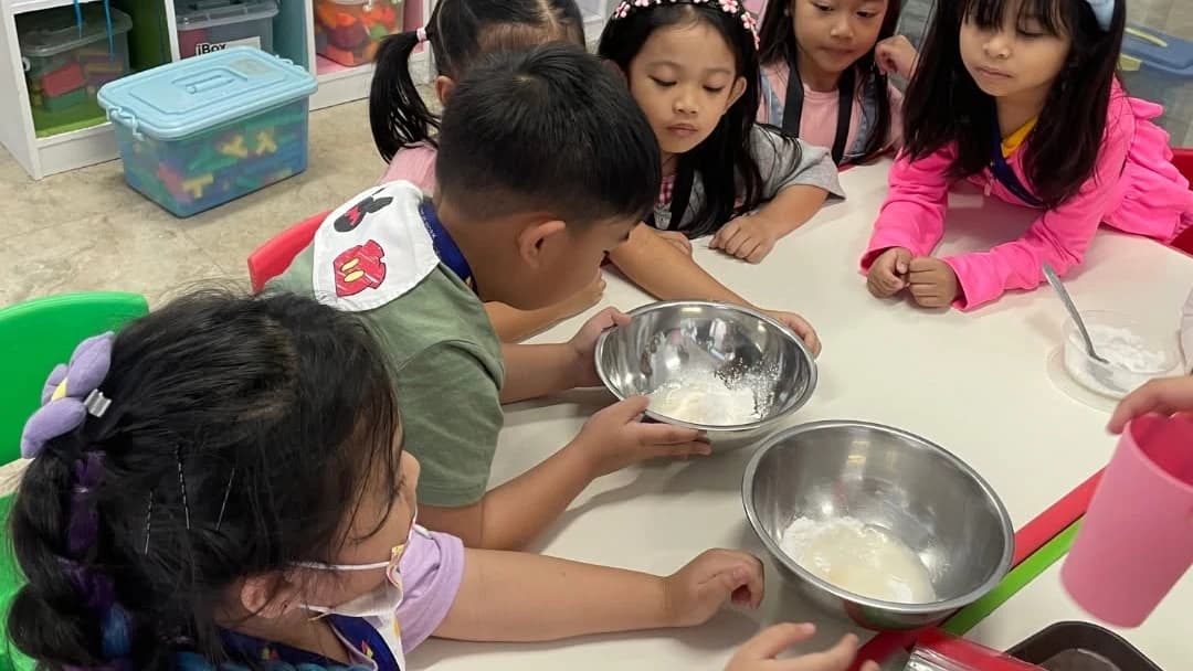 Children at a table with mixing bowls during a hands-on activity